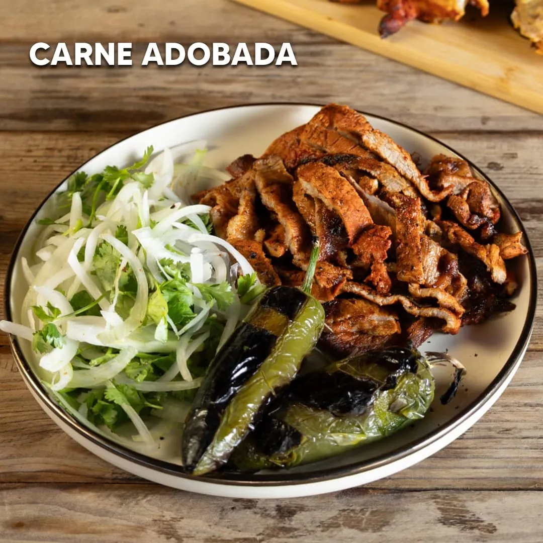 Plato de carne adobada con cebolla y cilantro y chiles toreados